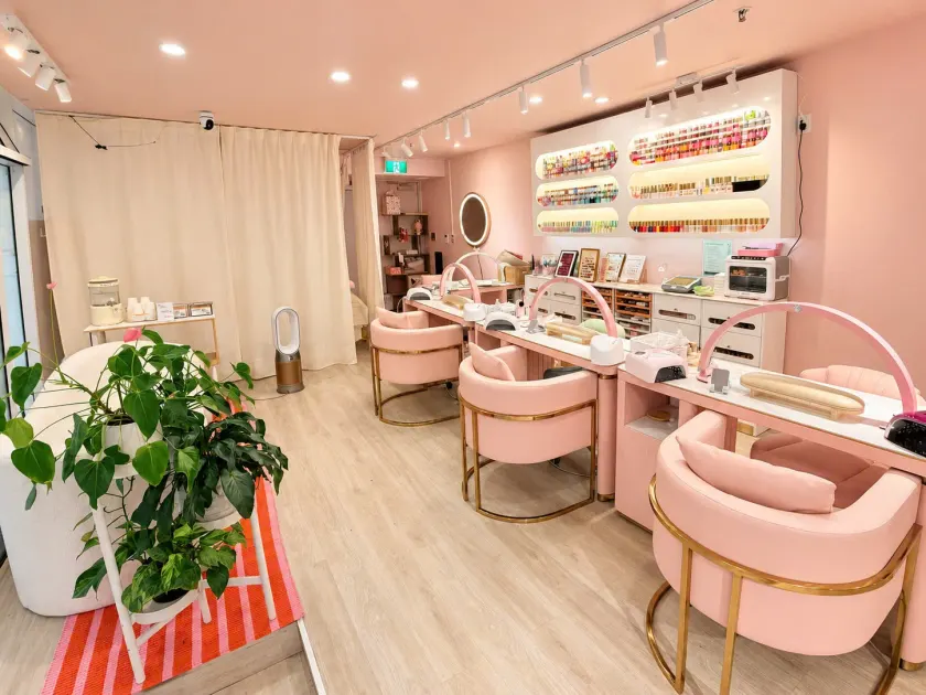 Manicure tables and blush pink chairs inside the salon